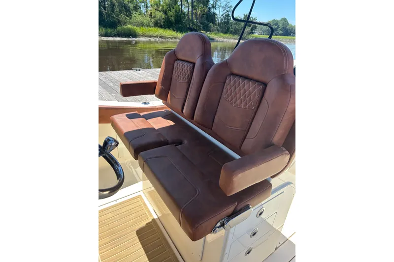  Yacht Photos Pics Luxurious brown leather seating on 2025 Scout 277 LXF boat, docked by a serene river.