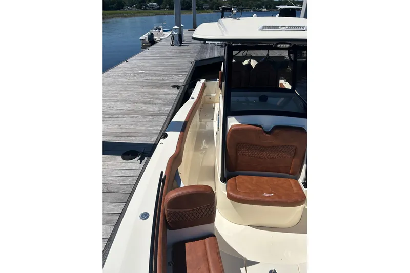  Yacht Photos Pics 2025 Scout 277 LXF boat docked, featuring luxurious brown leather seating.