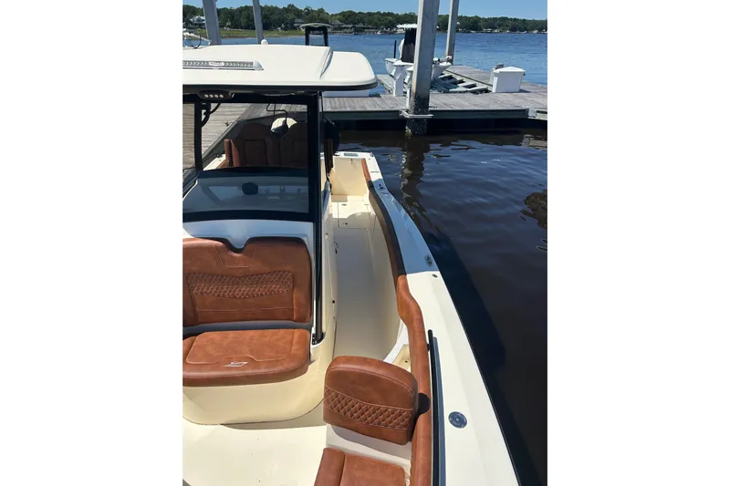  Yacht Photos Pics 2025 Scout 277 LXF boat with luxurious seating docked by the water.