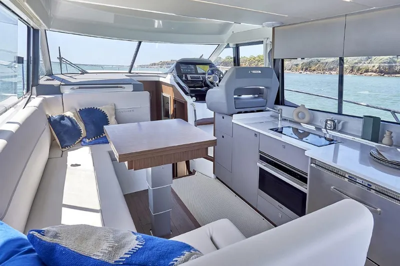  Yacht Photos Pics Luxurious interior of 2026 Beneteau Antares 12 Fly OB yacht with modern kitchen and seating.