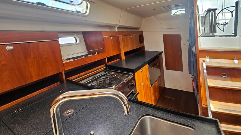 Acadia Yacht Photos Pics Interior of 2016 Hanse 415 yacht kitchen with wooden cabinets and modern appliances.
