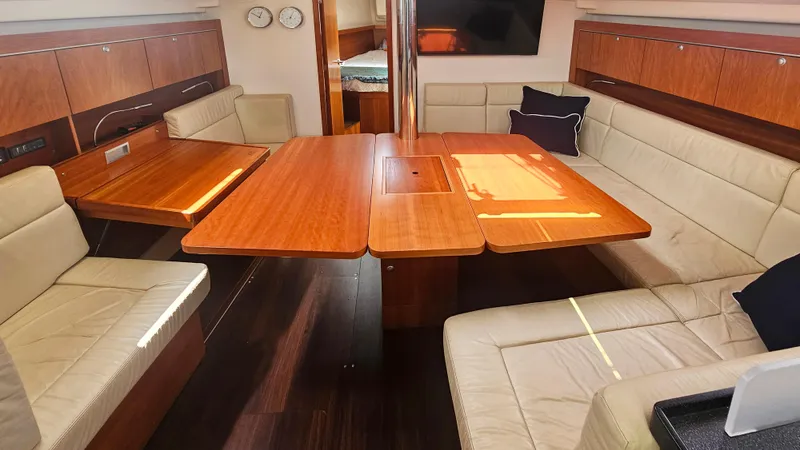 Acadia Yacht Photos Pics Luxurious interior of 2016 Hanse 415 yacht with wooden table and beige seating.