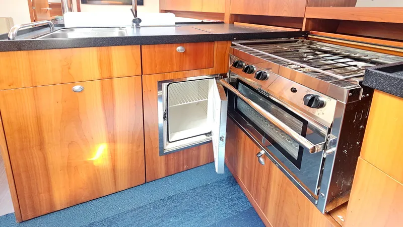 Acadia Yacht Photos Pics Modern kitchen in 2016 Hanse 415 yacht with stove, sink, and open fridge.
