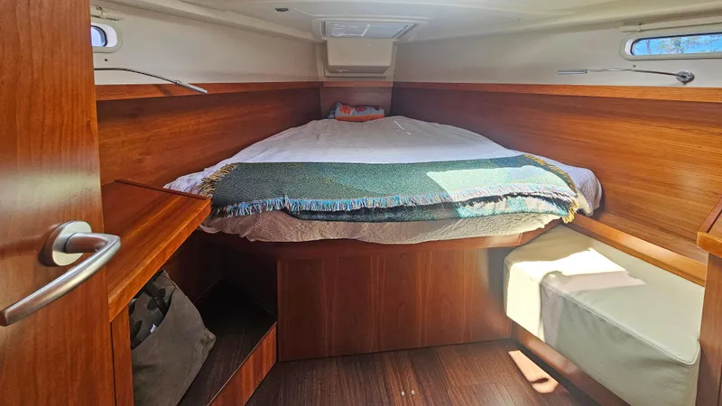Acadia Yacht Photos Pics Cozy cabin interior of 2016 Hanse 415 yacht with wooden finish and comfortable bedding.