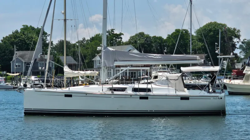 Acadia Yacht Photos Pics 2016 Hanse 415 sailboat docked in a marina, surrounded by trees and houses.