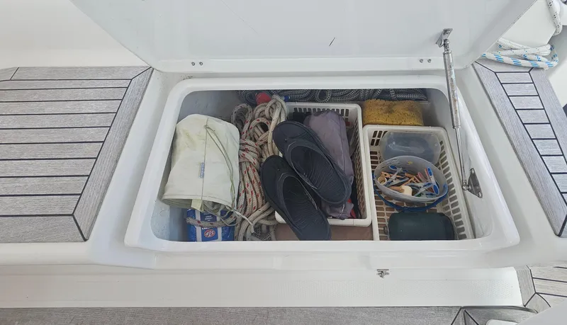 Acadia Yacht Photos Pics Storage compartment on a 2016 Hanse 415 yacht, containing ropes, shoes, and various supplies.