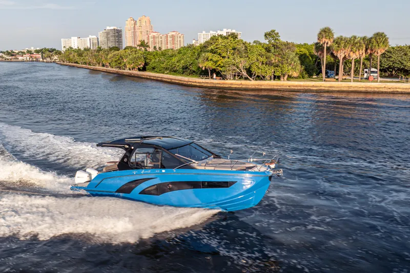  Yacht Photos Pics 2026 Hanover 347 boat cruising on a scenic waterway with city skyline backdrop.