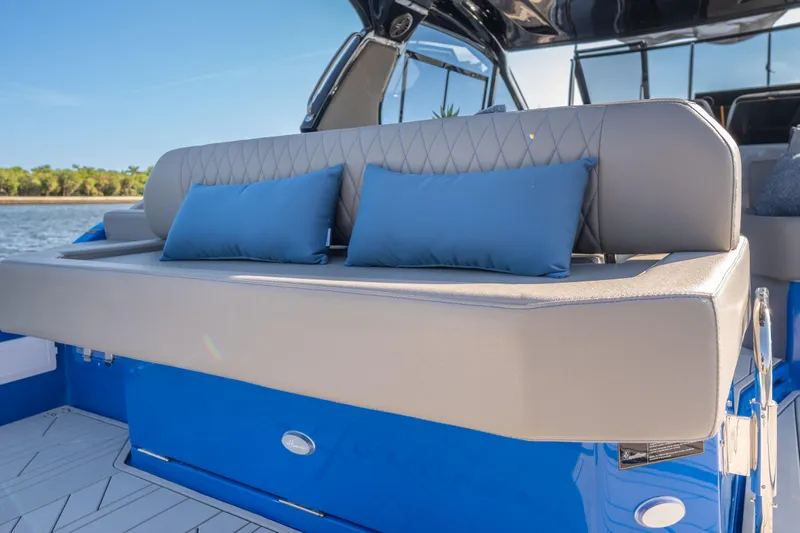  Yacht Photos Pics Luxurious seating on 2026 Hanover 347 boat with blue cushions, docked by the water.