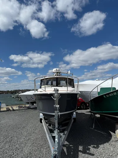  Yacht Photos Pics 2023 Ranger Tugs R-25 boat on trailer under blue sky with clouds.
