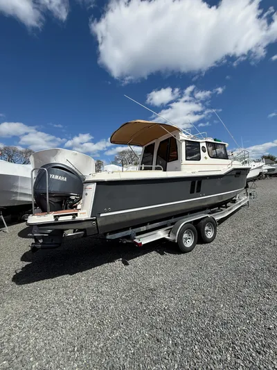  Yacht Photos Pics 2023 Ranger Tugs R-25 boat on trailer under blue sky with clouds.