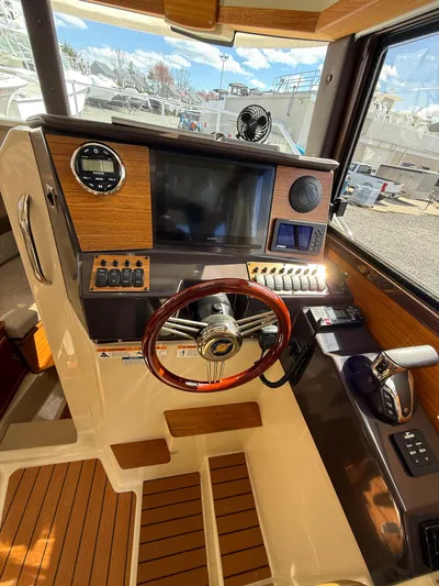 Yacht Photos Pics 2023 Ranger Tugs R-25 helm with wood accents and modern navigation controls.