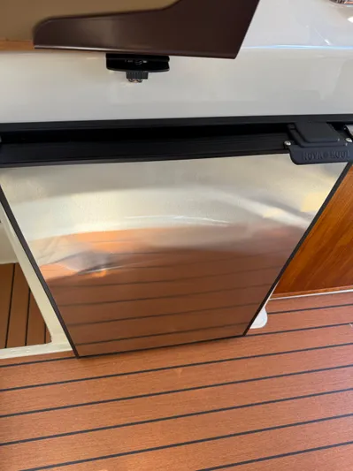  Yacht Photos Pics 2023 Ranger Tugs R-25 interior with stainless steel fridge and wood flooring.