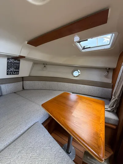  Yacht Photos Pics 2023 Ranger Tugs R-25 cabin interior with cozy seating and wooden table.