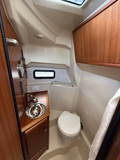  Yacht Photos Pics 2023 Ranger Tugs R-25 boat bathroom with wood cabinetry and stainless steel sink.