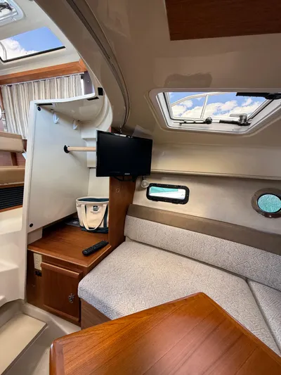  Yacht Photos Pics 2023 Ranger Tugs R-25 interior with cozy seating, TV, and skylight.