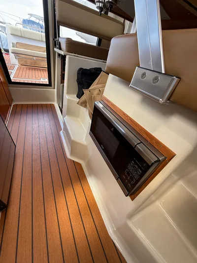  Yacht Photos Pics 2023 Ranger Tugs R-25 interior with wood flooring and built-in microwave.