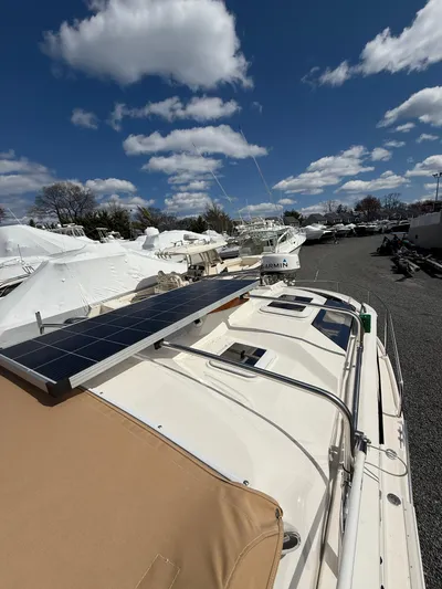 Yacht Photos Pics 2023 Ranger Tugs R-25 boat with solar panel, docked under a blue sky with clouds.