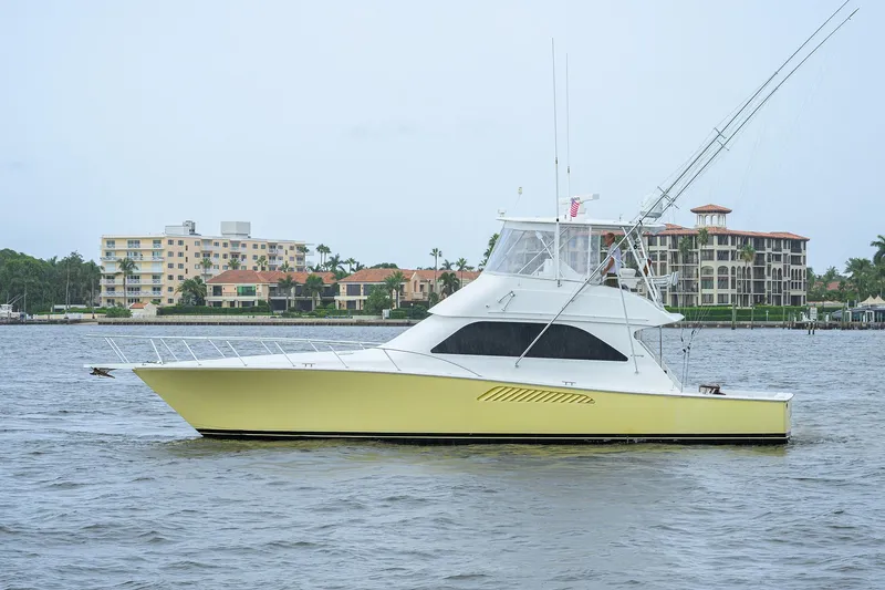 Island Girl Yacht Photos Pics 2004 Viking 48 Convertible yacht on water with coastal buildings in background.