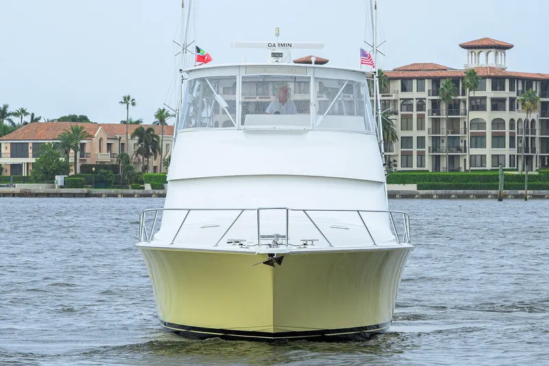 Island Girl Yacht Photos Pics 2004 Viking 48 Convertible yacht on water, with luxury buildings in the background.