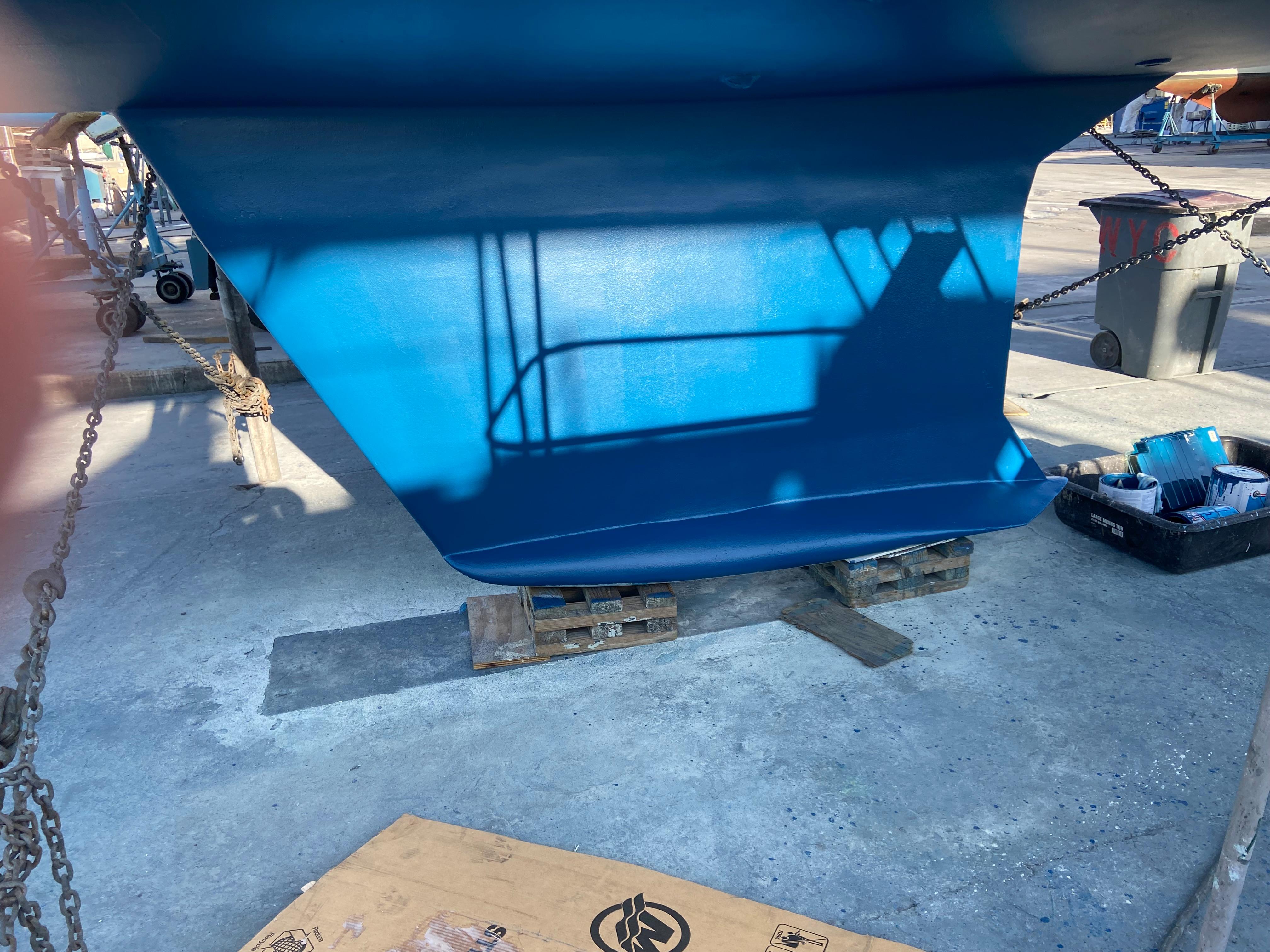 Blue hull of 2000 Hunter Passage 420 sailboat on dry dock.