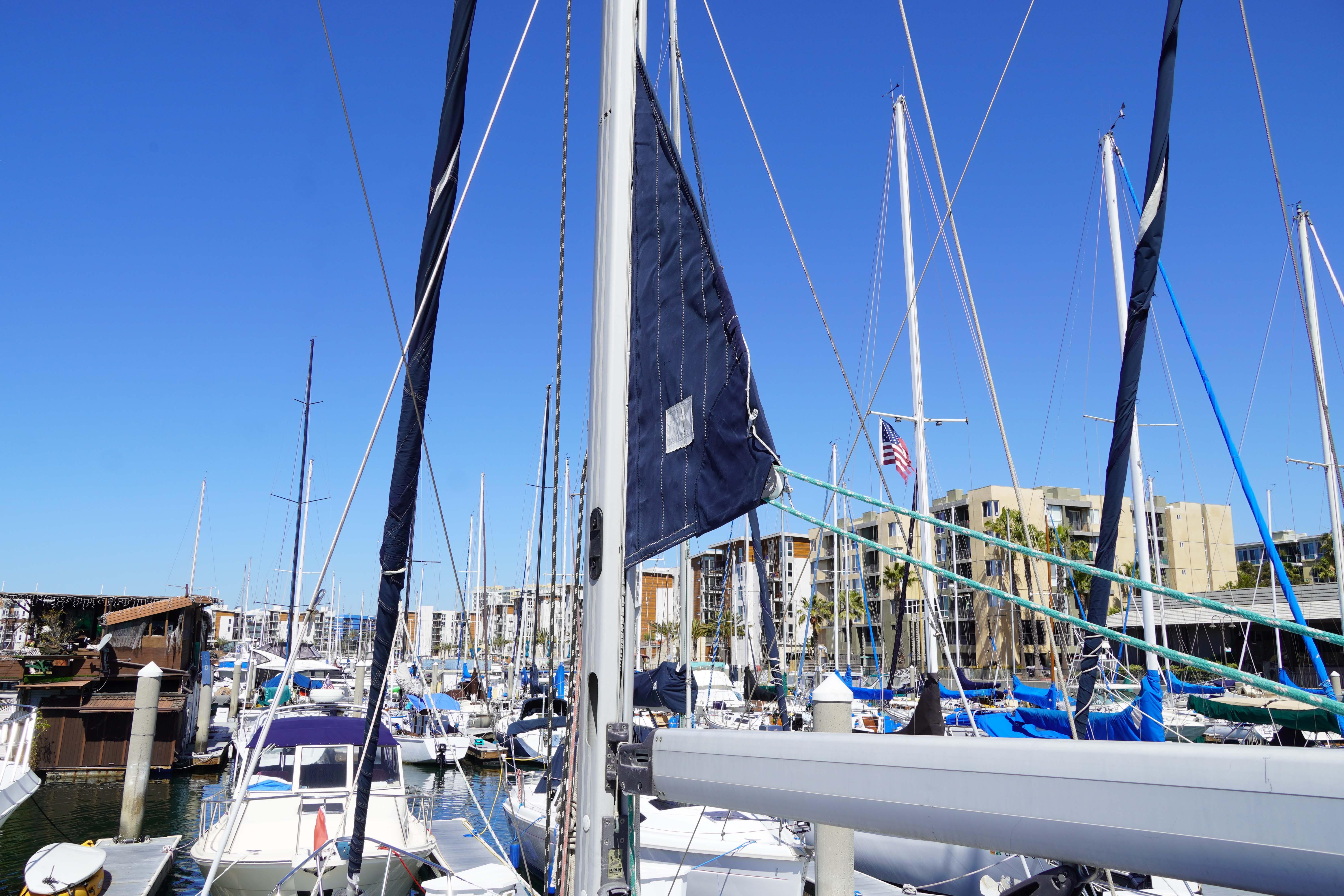 Marina with multiple sailboats, including a 2000 Hunter Passage 420, under a clear blue sky.