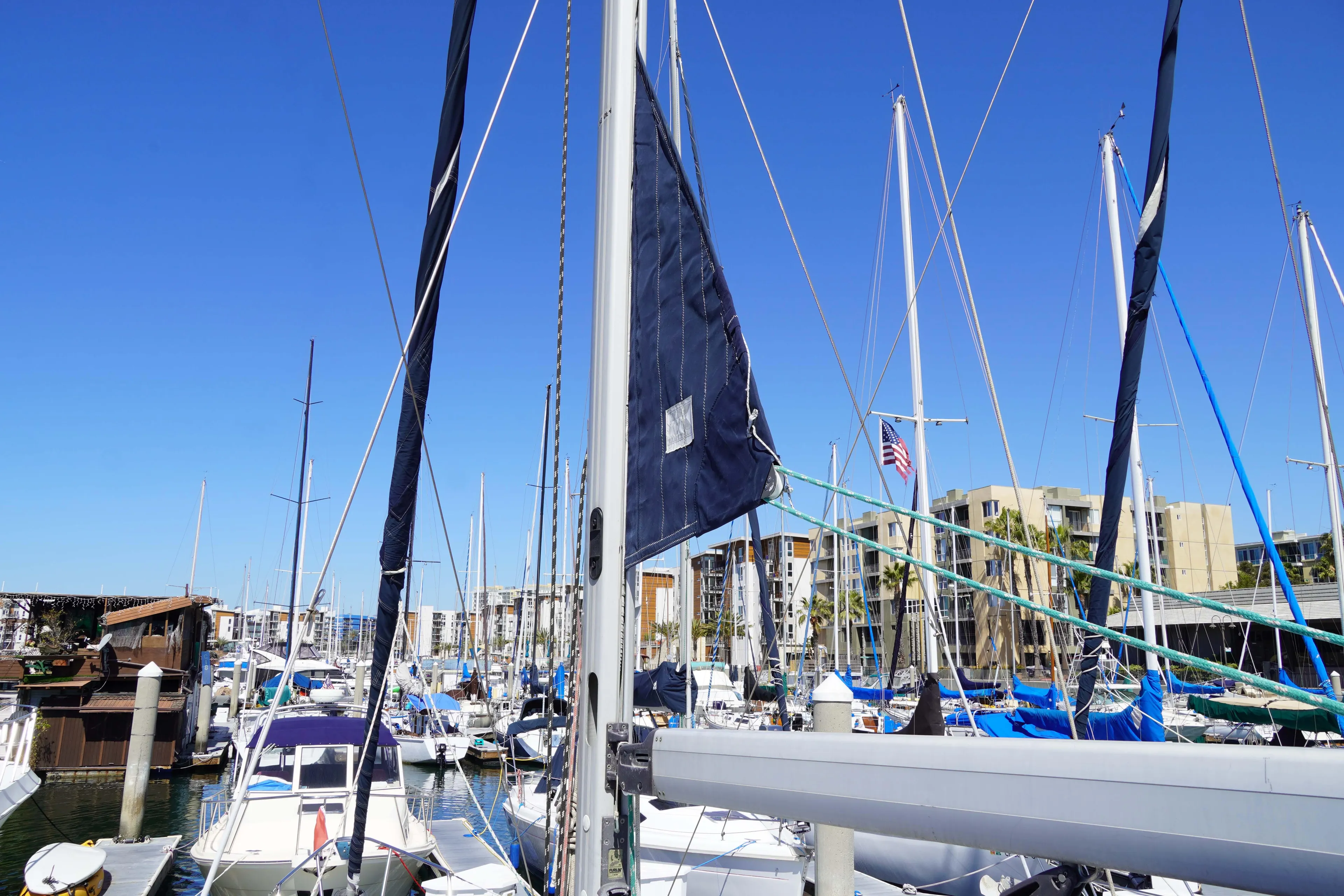 Marina with multiple sailboats, including a 2000 Hunter Passage 420, under a clear blue sky.