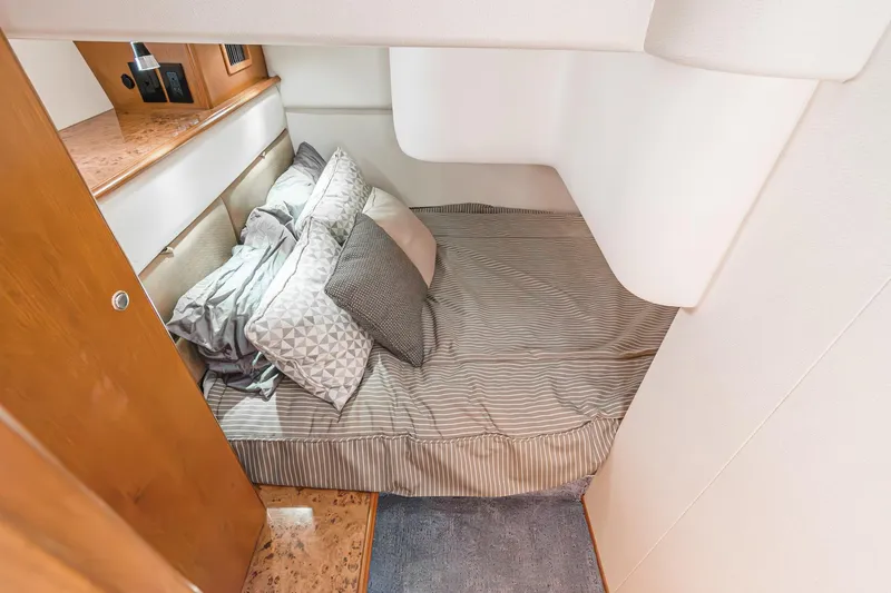 Nauti Pops Yacht Photos Pics 2007 Silverton Convertible cabin interior with cozy bed and striped bedding.