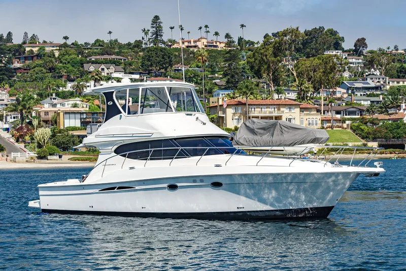 Nauti Pops Yacht Photos Pics 2007 Silverton Convertible yacht cruising near scenic coastal homes.