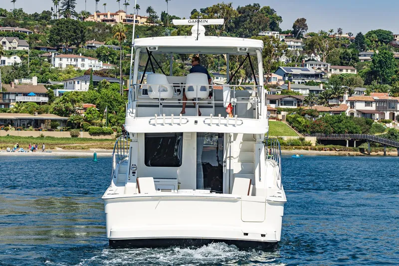 Nauti Pops Yacht Photos Pics 2007 Silverton Convertible yacht cruising near scenic coastal homes.