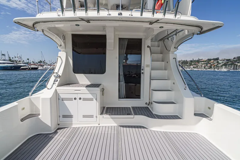 Nauti Pops Yacht Photos Pics 2007 Silverton Convertible yacht deck with stairs, docked in a marina under clear skies.