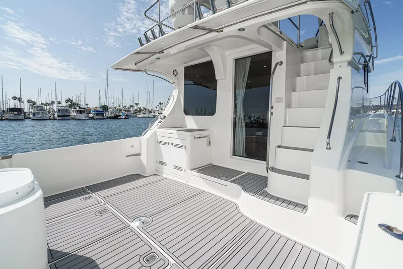 Nauti Pops Yacht Photos Pics 2007 Silverton Convertible yacht deck with marina view, featuring sleek design and modern amenities.