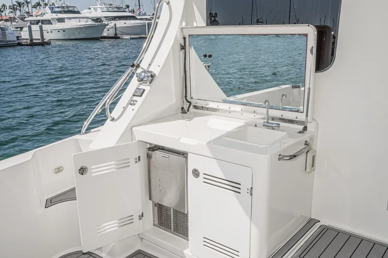 Nauti Pops Yacht Photos Pics 2007 Silverton Convertible yacht with outdoor sink and storage, docked at marina.