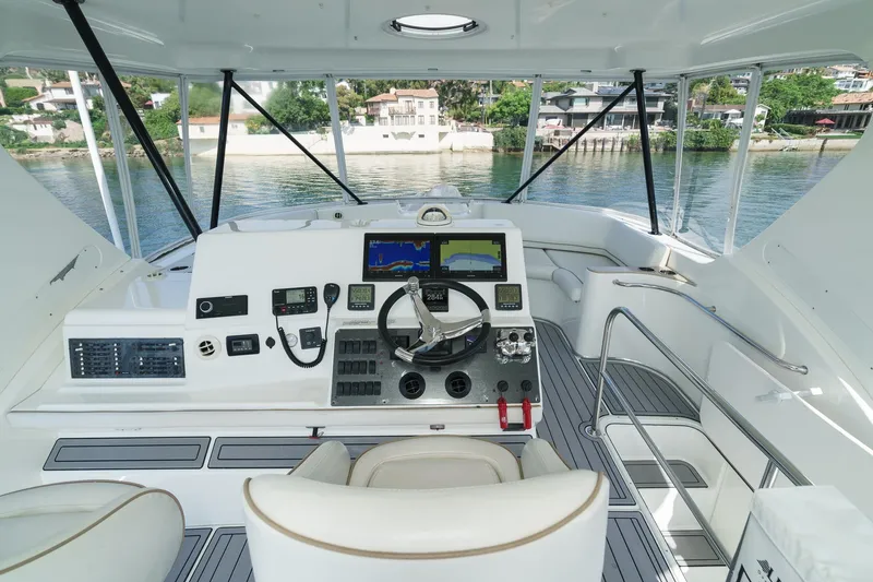 Nauti Pops Yacht Photos Pics 2007 Silverton Convertible yacht helm with modern navigation equipment and waterfront view.