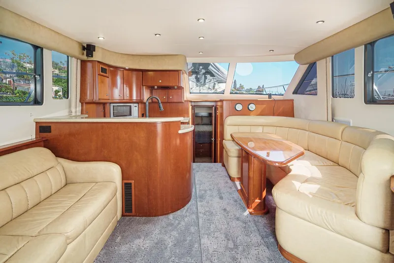 Nauti Pops Yacht Photos Pics Luxurious interior of a 2007 Silverton Convertible yacht with leather seating and wooden cabinetry.