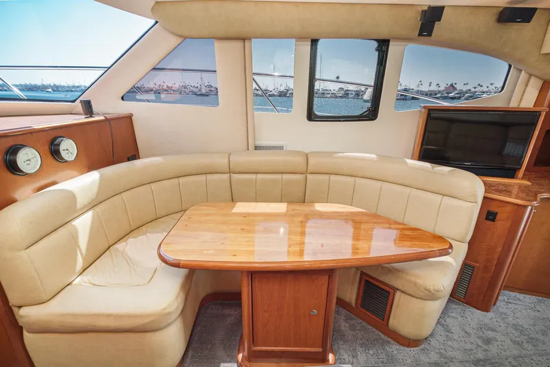 Nauti Pops Yacht Photos Pics Luxurious 2007 Silverton Convertible yacht interior with beige seating and wooden table.