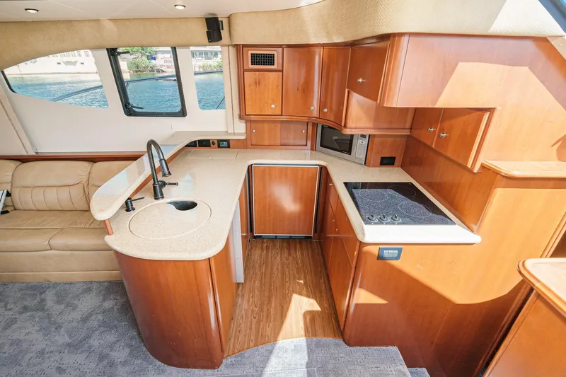 Nauti Pops Yacht Photos Pics 2007 Silverton Convertible yacht interior with modern kitchen and seating area.