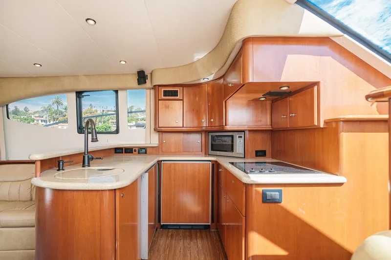 Nauti Pops Yacht Photos Pics Luxurious 2007 Silverton Convertible yacht interior with modern kitchen and sleek wood cabinetry.