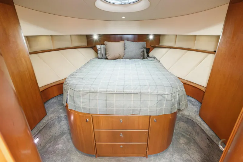 Nauti Pops Yacht Photos Pics Luxurious 2007 Silverton Convertible yacht bedroom with elegant wood finish and cozy bedding.