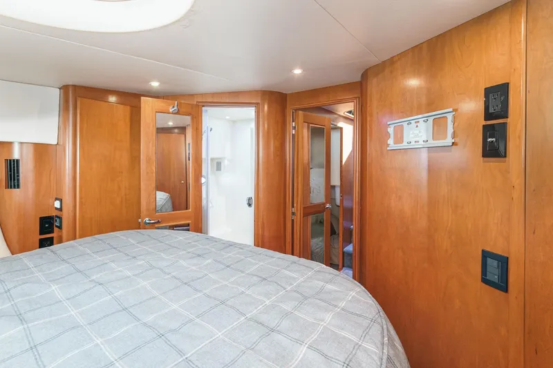 Nauti Pops Yacht Photos Pics Interior of 2007 Silverton Convertible yacht with wood paneling and cozy bedroom.