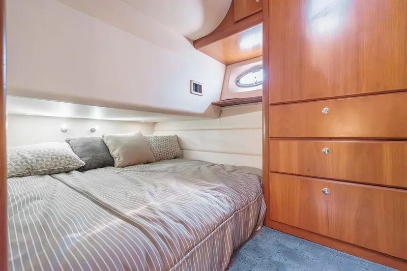 Nauti Pops Yacht Photos Pics 2007 Silverton Convertible yacht cabin with cozy bed and wooden storage cabinets.