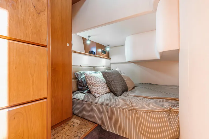 Nauti Pops Yacht Photos Pics 2007 Silverton Convertible yacht interior with cozy bed and wooden cabinetry.