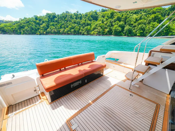 Yolo Yacht Photos Pics Fairline 50 yacht deck, 2014 model, with scenic ocean and lush greenery backdrop.