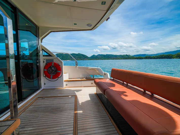 Yolo Yacht Photos Pics 2014 Fairline 50 yacht deck with seating, overlooking serene waters and distant hills.