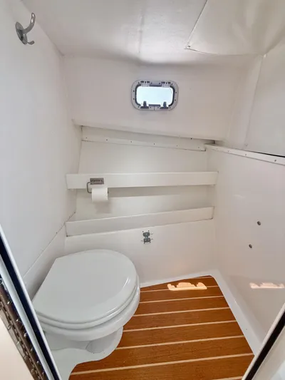  Yacht Photos Pics 2021 Steiger Craft 31 Chesapeake boat bathroom with wooden floor and small window.