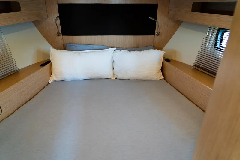  Yacht Photos Pics Cozy cabin bed in 2022 Bavaria SR41 yacht with wooden accents and soft pillows.