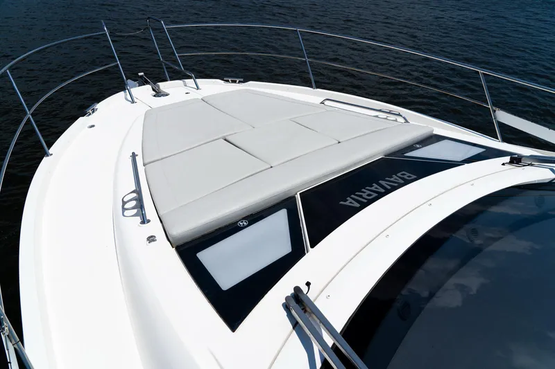  Yacht Photos Pics 2022 Bavaria SR41 yacht deck with sunbathing area, sleek design, and railing on calm water.
