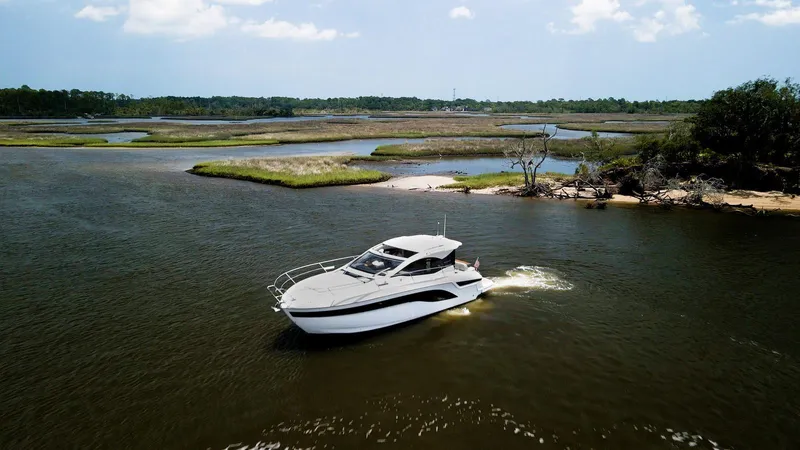  Yacht Photos Pics 2022 Bavaria SR41 yacht cruising in a scenic, tranquil waterway.