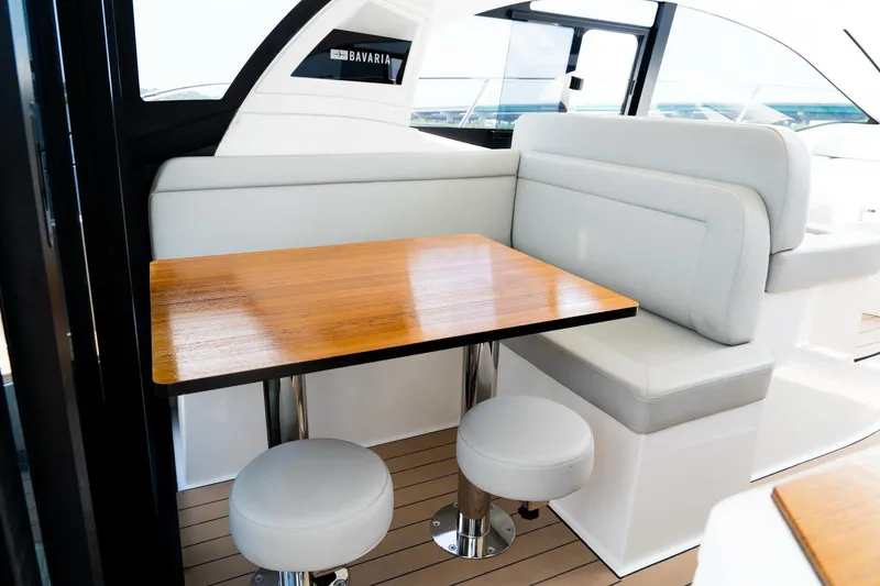  Yacht Photos Pics Interior of 2022 Bavaria SR41 yacht with wooden table and white seating.