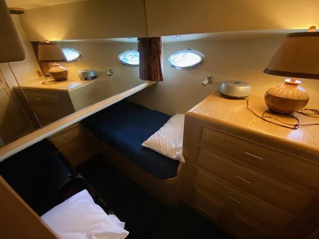  Yacht Photos Pics Cozy cabin interior of 1989 Ocean Alexander 42 yacht with wooden furnishings and porthole windows.