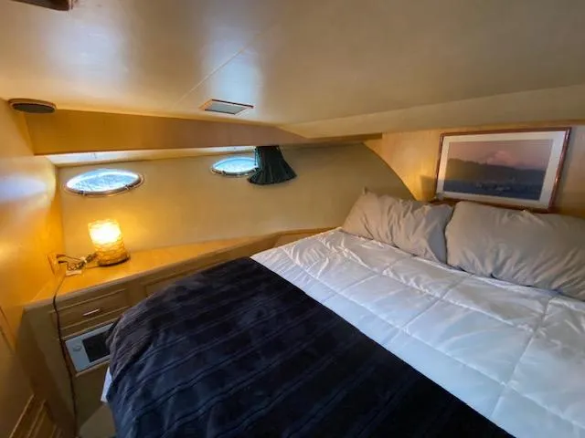  Yacht Photos Pics Cozy cabin interior of 1989 Ocean Alexander 42 yacht with bed and porthole windows.